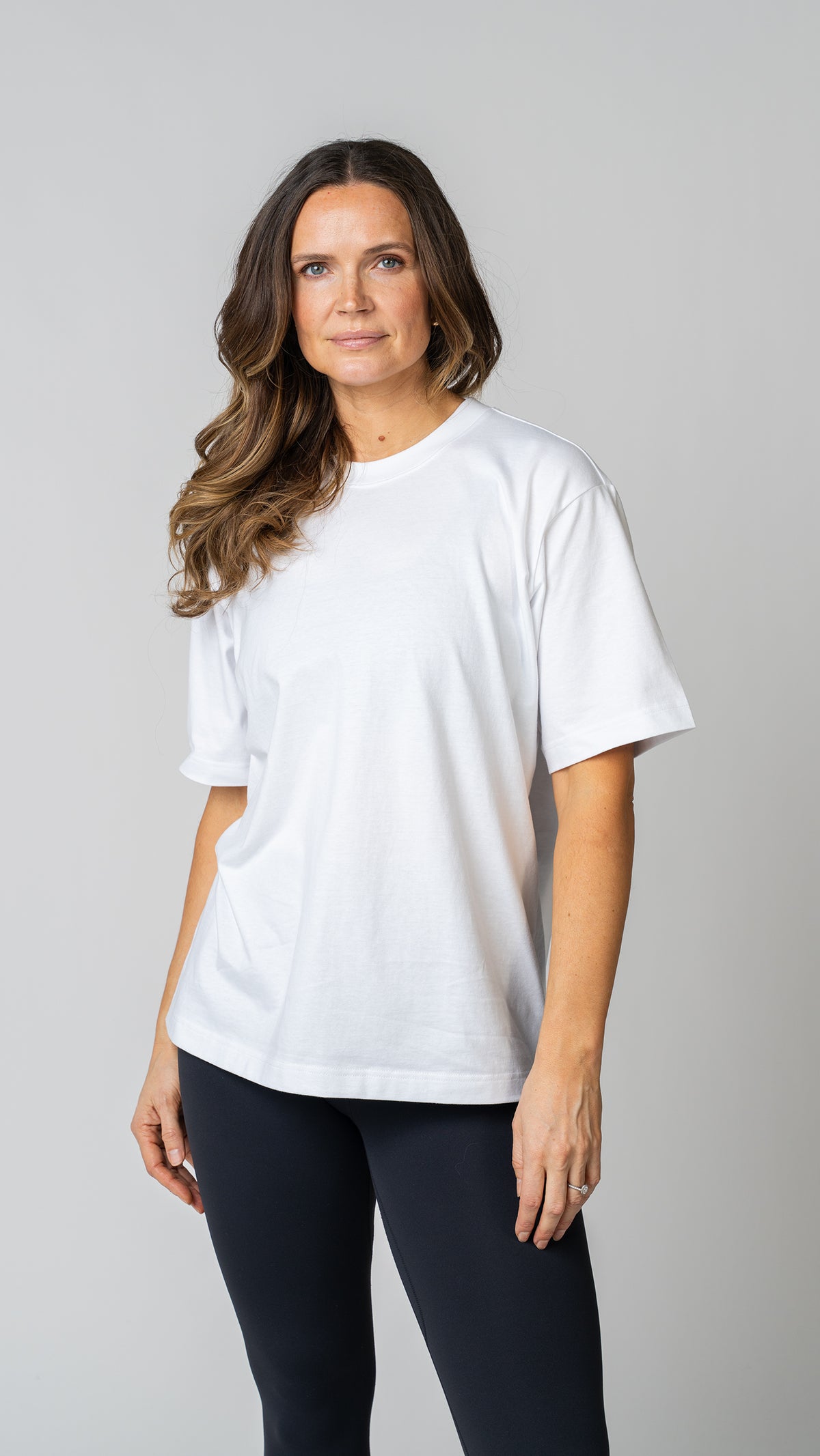 women wearing a white oversized tee with black leggings. 