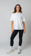 women wearing a white oversized tee with black leggings. 