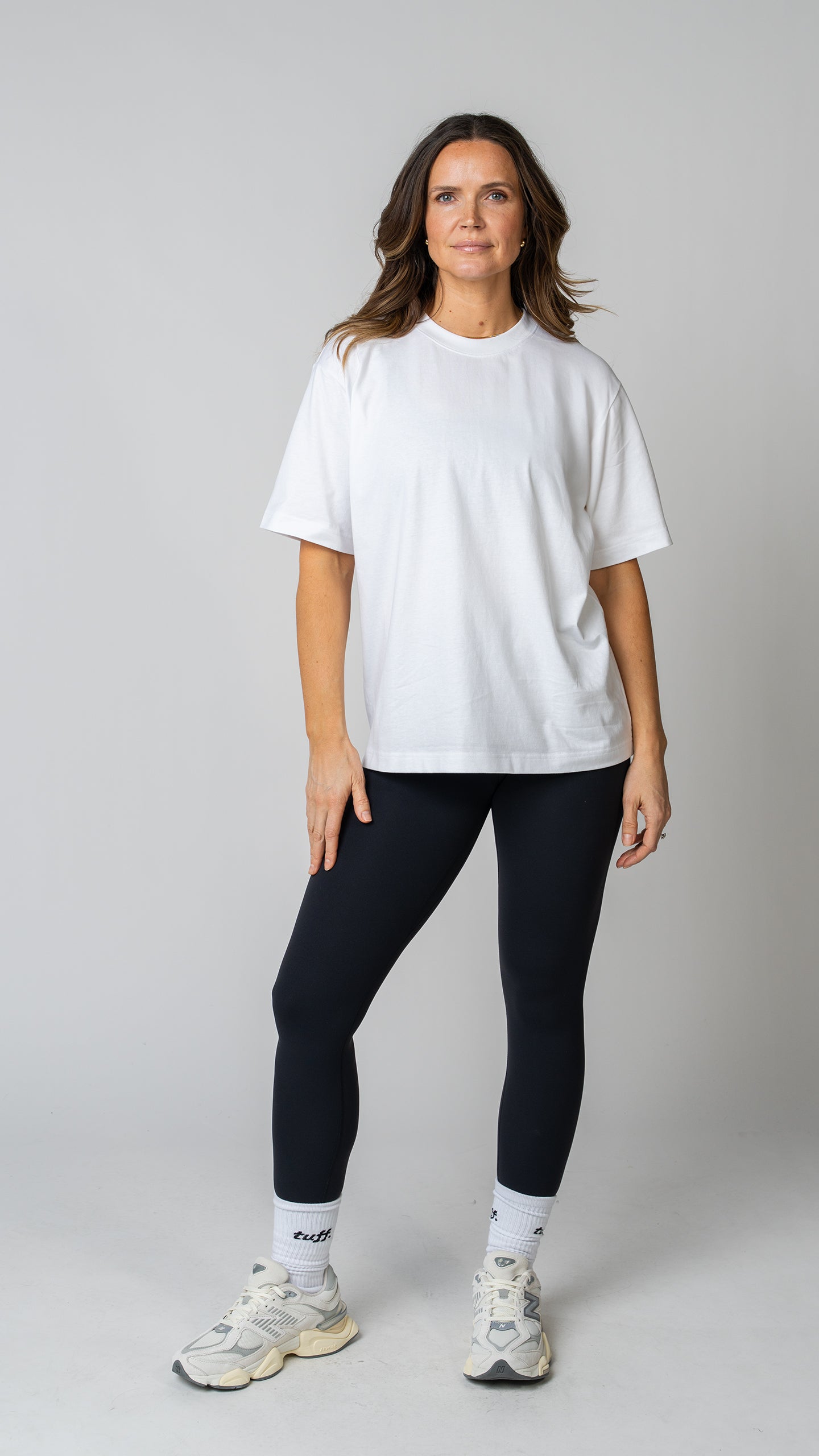 women wearing a white oversized tee with black leggings. 
