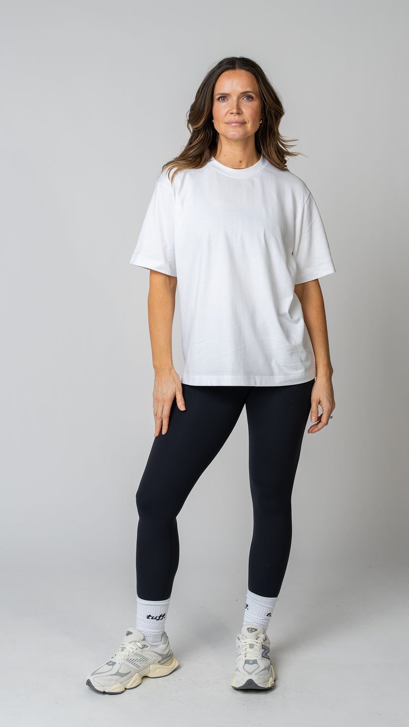 women wearing a white oversized tee with black leggings. 